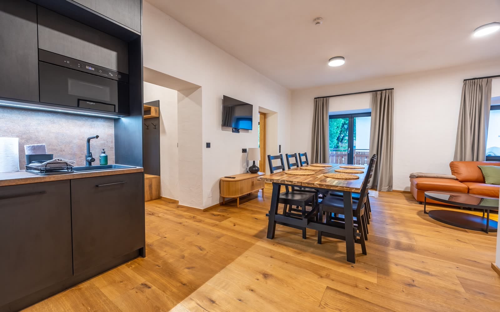 Kitchen, dining table and living area of the three-bedroom apartment