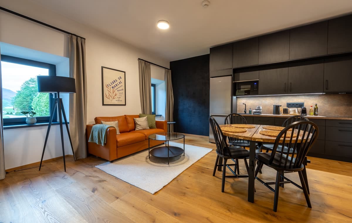 Living room, dining table and kitchen of the two-bedroom apartment with balcony