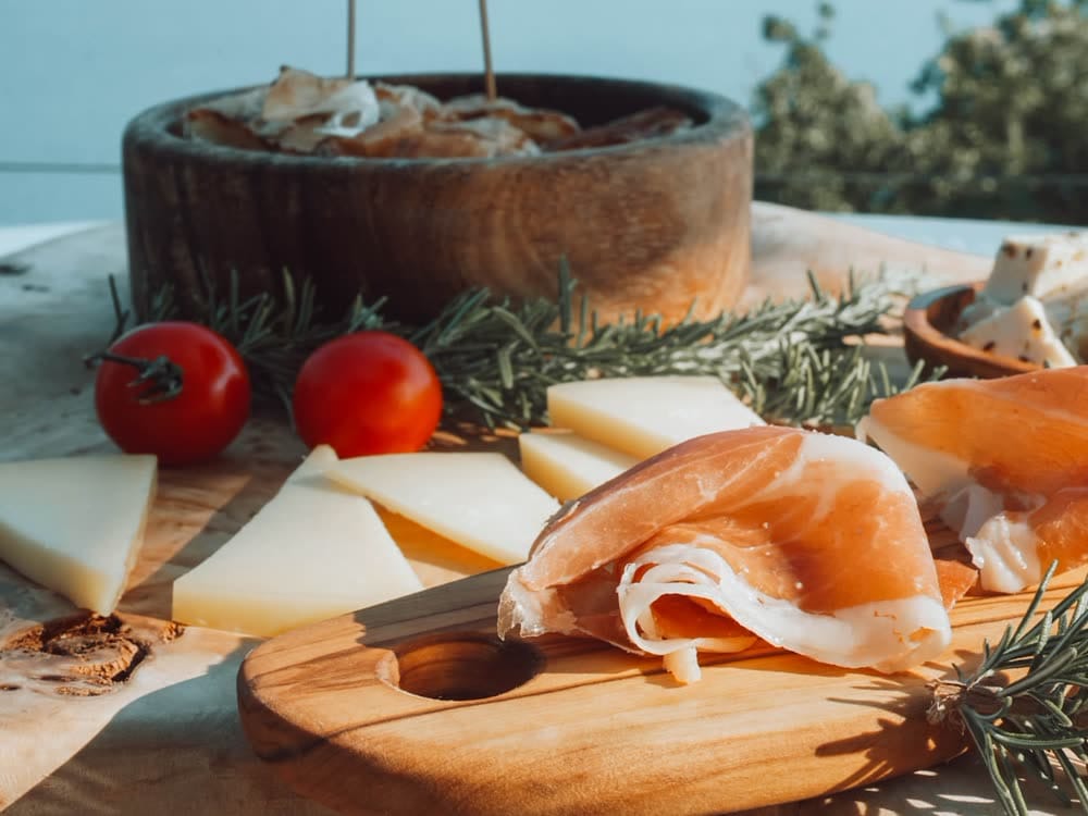 Cured ham and mountain cheese on a wooden board